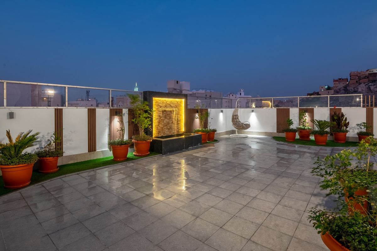 سطح العمارة ليلاً مع الشلال والنباتات